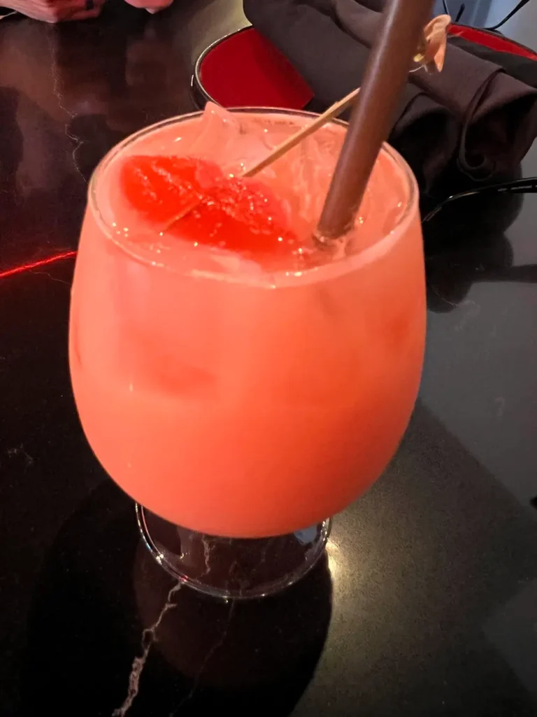 tropical iced mocktail served in a glass goblet with a straw.